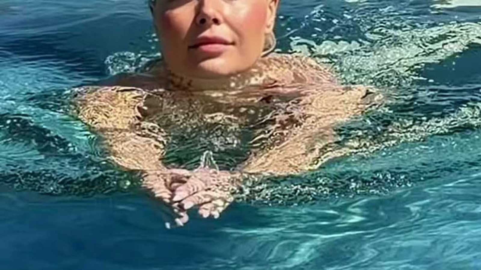 Викторија Лоба на плажа во пастелен костим — црвена марама како моден детаљ